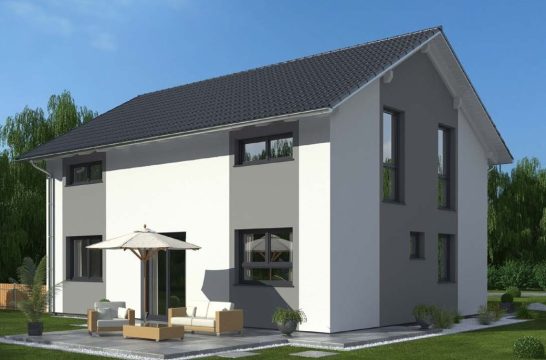 Modernes zweigeschossiges Haus mit Terrasse und Sonnenschirm in einer grünen Umgebung.